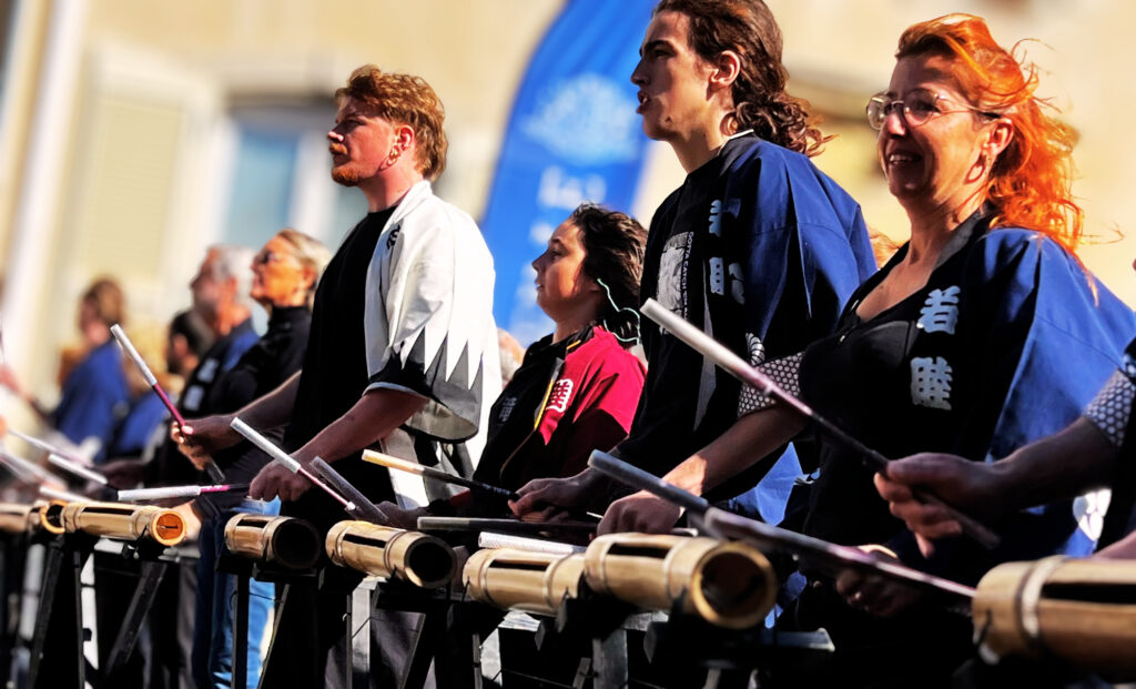 Les Pousses jouent des percussions en bambou sur scène.